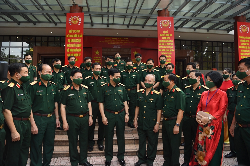 Thượng tướng Phan Văn Giang, Ủy viên Bộ Chính trị, Phó bí thư Quân ủy Trung ương, Bộ trưởng Bộ Quốc phòng trò chuyện cùng các đồng chí nguyên lãnh đạo Bộ Quốc phòng và các cử tri tại điểm bầu cử. Ảnh: Trọng Hải.